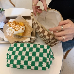 Detailed interior of checkered knitted cosmetic bag with zipper and soft fabric lining