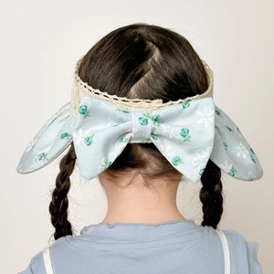 Detail of floral blue bow headband with delicate lace edges on child model's hair