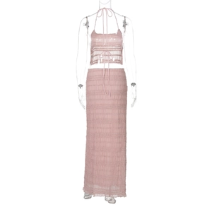 Détail du crop top dos nu rose et de la jupe longue en tissu plissé texturé