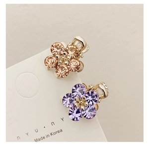 Detailed view of mini crystal flower hair claws in champagne and light purple tones
