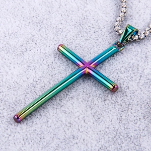 Macro shot of rainbow-tinted stainless steel cross pendant on a silver box chain