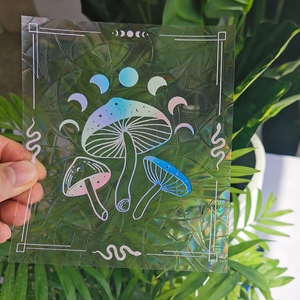 Holographic mushroom and moon phase suncatcher sticker reflecting a rainbow prism effect