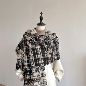Elegant black and white checkered scarf featuring large rose patterns on a model