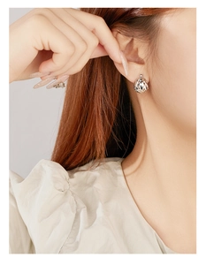 Close-up of S925 sterling silver hoop earrings with textured laser-cut diamond pattern