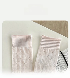 Detail of light pink mesh sock with diamond hollow pattern and elastic ribbed cuff