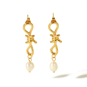 Detailed view of the 18k gold-plated twisted knot earrings with hanging baroque pearls