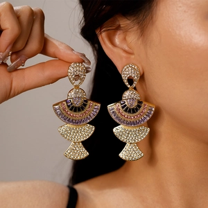 Macro shot of oversized vintage fan-shaped earrings with colorful sparkling rhinestones