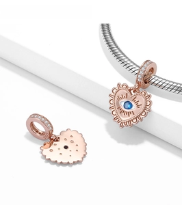 Detailed view of rose gold heart charm with S925 engraving and blue evil eye stone