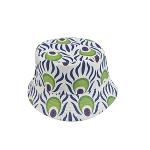 Close-up of white bucket hat featuring abstract peacock feather patterns in green and purple