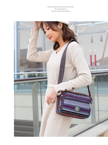 Close-up of ethnic striped canvas crossbody bag with adjustable strap and zip pockets