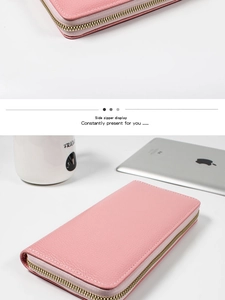 Detalle de cartera rosa de piel granulada con cremallera dorada y diseño interior de fuelle