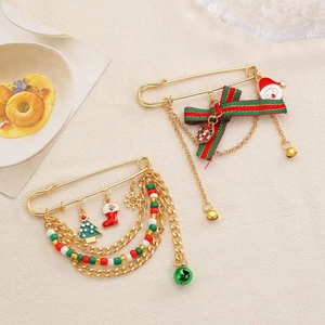 Christmas safety pin brooch set with Santa, tree and snowflake charms on white linen