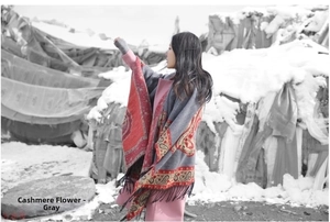 Detailed paisley pattern and tassels on gray ethnic cashmere shawl in snowy outdoor setting