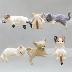Close-up of cute cat and dog figurines resting on transparent display shelves