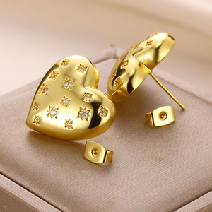 Close-up of gold heart-shaped zircon earrings with star pattern on jewelry box