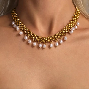 Gros plan détaillé du collier en or 18 carats avec de petits pendentifs en perles blanches