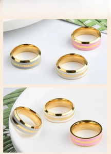 Detailed macro view of gold plated rings featuring pink, white, and blue enamel stripes