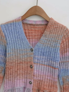 Detail of V-neck gradient knit cardigan showing colorful ribbed texture and buttons