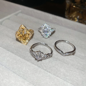 Detailed view of four zircon rings in gold and silver plating on a jewelry tray