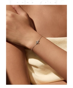 Delicate S925 silver cross bracelet with shimmering pavé diamonds on a model's wrist
