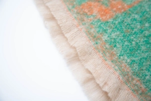 Detailed macro view of woven flower pattern fabric with soft beige fringe tassels