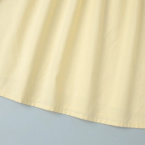 Gros plan détaillé sur l'ourlet à double couture du tissu en coton jaune crème doux