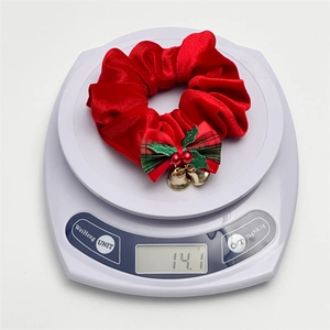 Red velvet Christmas scrunchie with a plaid bow, holly berries, and gold jingle bells