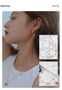 Detail view of emerald style gold plated necklace and earrings set on model and flat lay