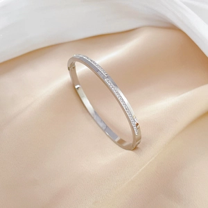 Bracelet ovale en acier inoxydable argenté pavé de cristaux sur fond de soie de luxe