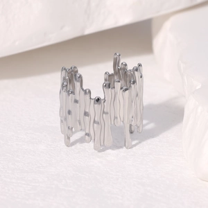 Bague minimaliste en métal liquide argenté avec design goutte de lave sur fond de pierre blanche