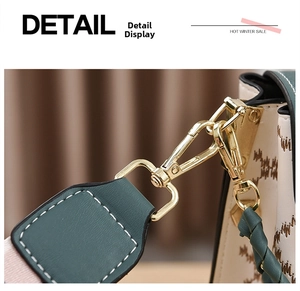 Detail of cream leather bag with brown embroidery, green trim and gold metal hook