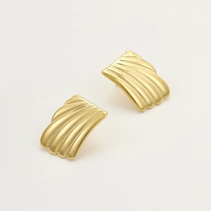 Macro detail of golden fan-shaped earrings with textured shell-like radiating metal patterns