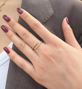 Close-up of golden adjustable snake ring with micro-set zircons on a model's hand