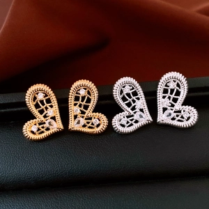 Détail des boucles d'oreilles cœur évidé en or et argent avec cristaux brillants