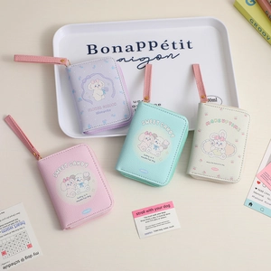 Detail of cute cartoon coin purses with wrist strap in pastel colors for girls