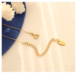Macro view of 18K gold plated chain extension with spring clasp and K18 engraving
