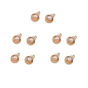 Detailed view of ten golden alloy shell pendants with white pearls for DIY jewelry making