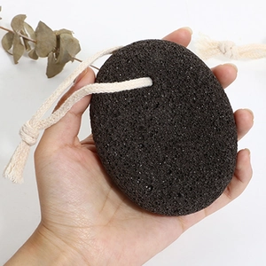 Natural black volcanic pumice stone for foot care with cotton hanging rope on white background