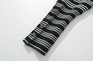 Detail of striped knit cardigan cuff with decorative black buttons and fine texture