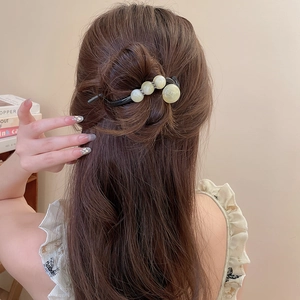 Nahaufnahme einer schwarzen Haarspange mit hellgrünen Perlen im Vintage-Stil aus China