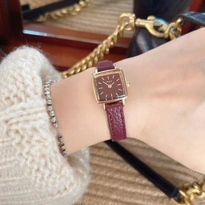 Classic square watch with red leather strap and gold case on woman's wrist