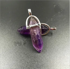 Natural purple amethyst hexagonal crystal pendant with silver metal bail on grey surface