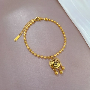 Close-up of golden stainless steel bead bracelet with Chinese Fu character lock charm