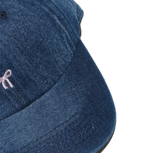 Detail of dark blue denim baseball cap with pink embroidery and cotton twill texture