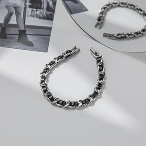 Minimalist silver steel chain bracelet with black leather woven details in a luxury style