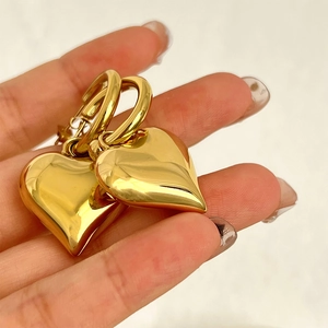Polished gold heart drop earrings with high-shine mirror finish on classic hoops
