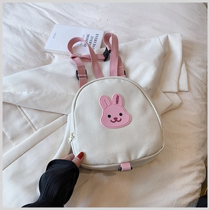 Detailed view of mini white canvas backpack with pink rabbit embroidery and soft straps
