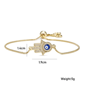 Golden Hamsa Hand bracelet with sparkling cubic zirconia and blue evil eye detail