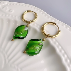 Detail shot of vintage emerald green glass drop earrings with 18K gold-plated hoops