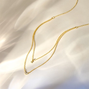 Detail of S925 silver gold double-layered necklace with sparkling star and moon pendants